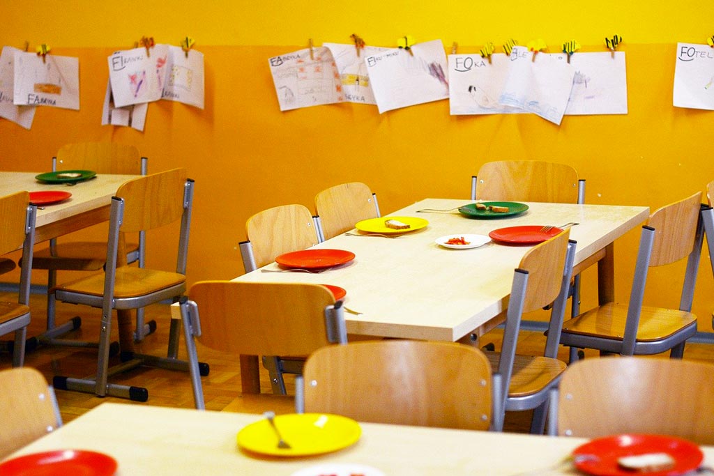 Foto di una scuola con piatti colorati sui banchi