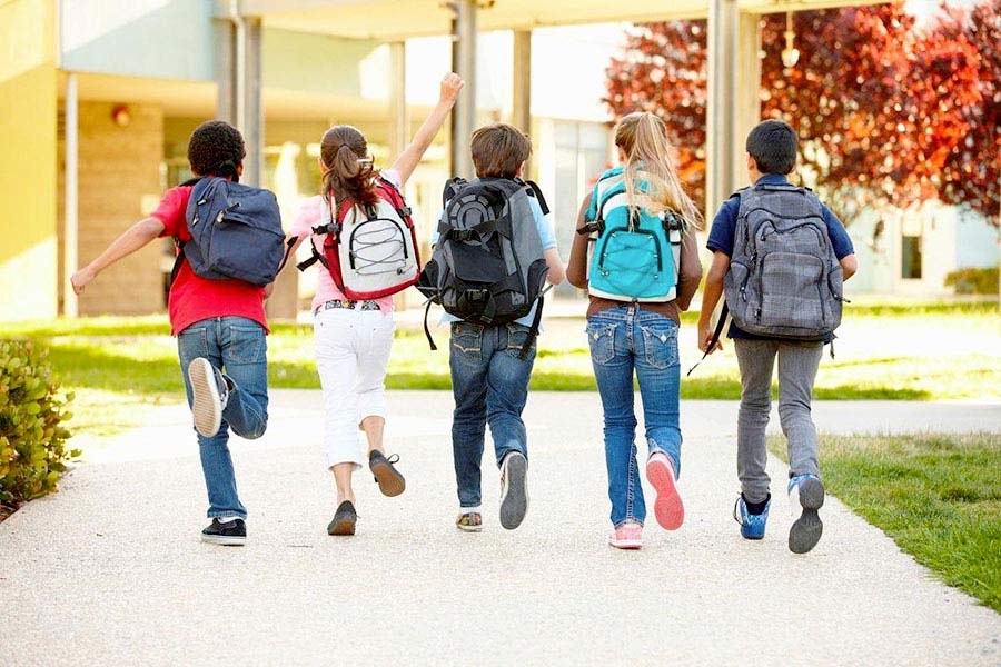 ragazzi che entrano a scuola tenendosi per mano